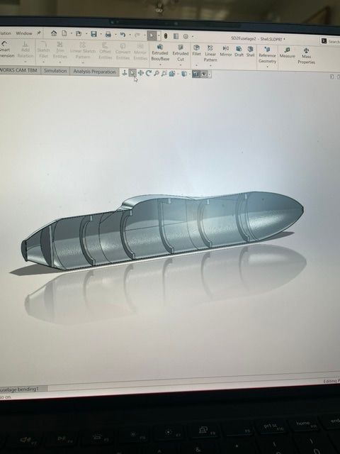 SolidWorks screen showing a shelled fuselage body, open along one side to reveal a series of internal ring bulkheads.
